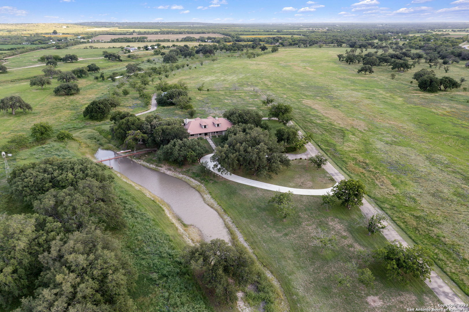 an aerial view of a house with a yard and lake view