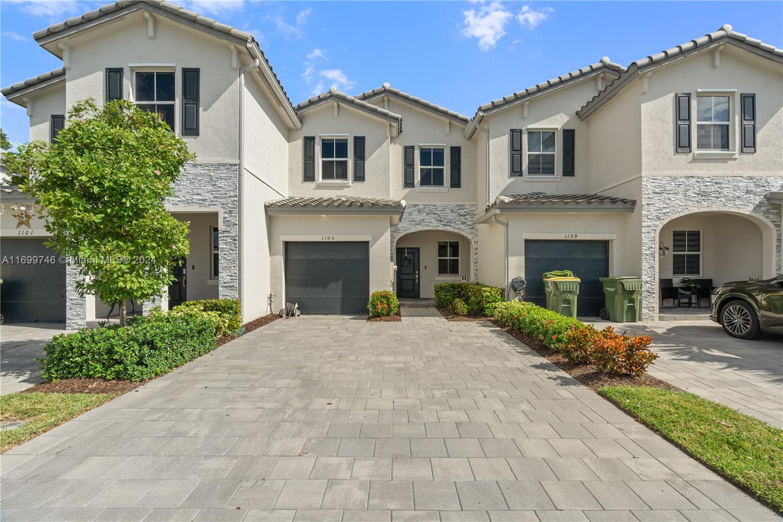 a front view of a house with yard and parking