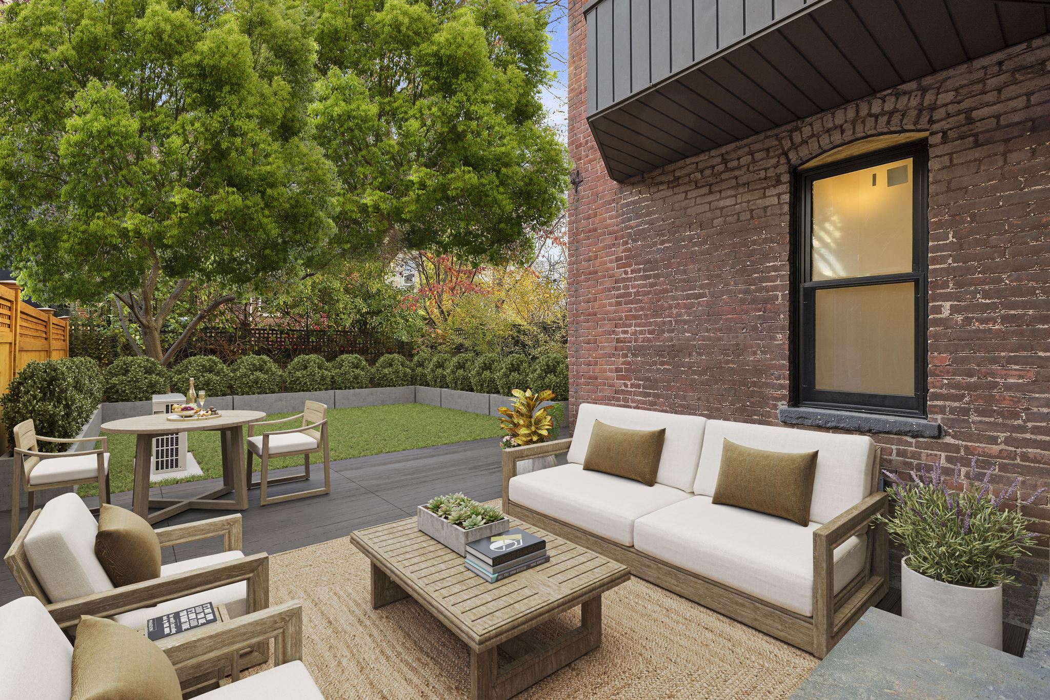 a view of a patio with couches table and chairs with potted plants and floor to ceiling window