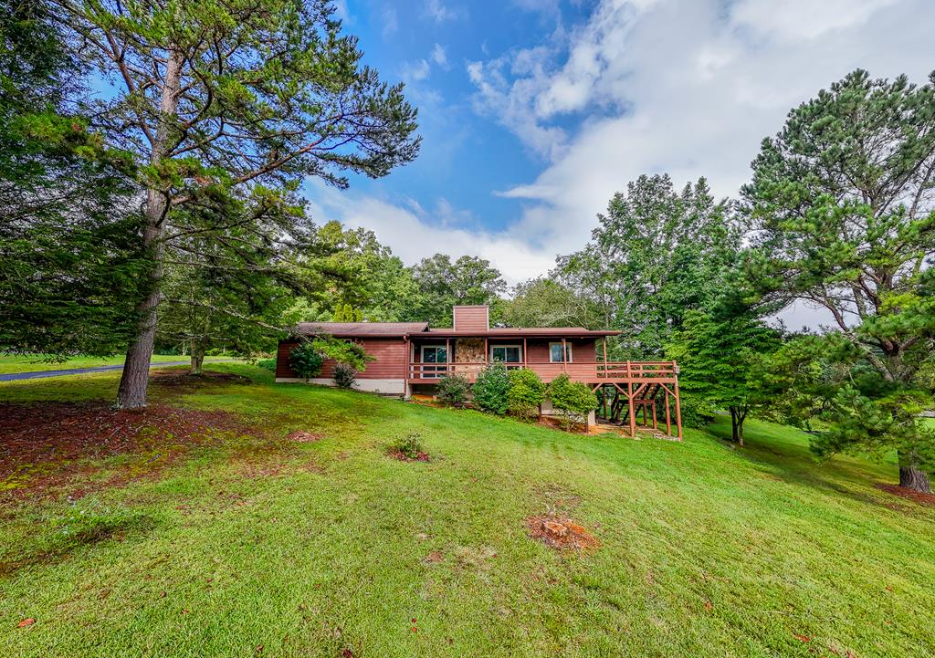 a view of backyard of house with wooden fence and trees