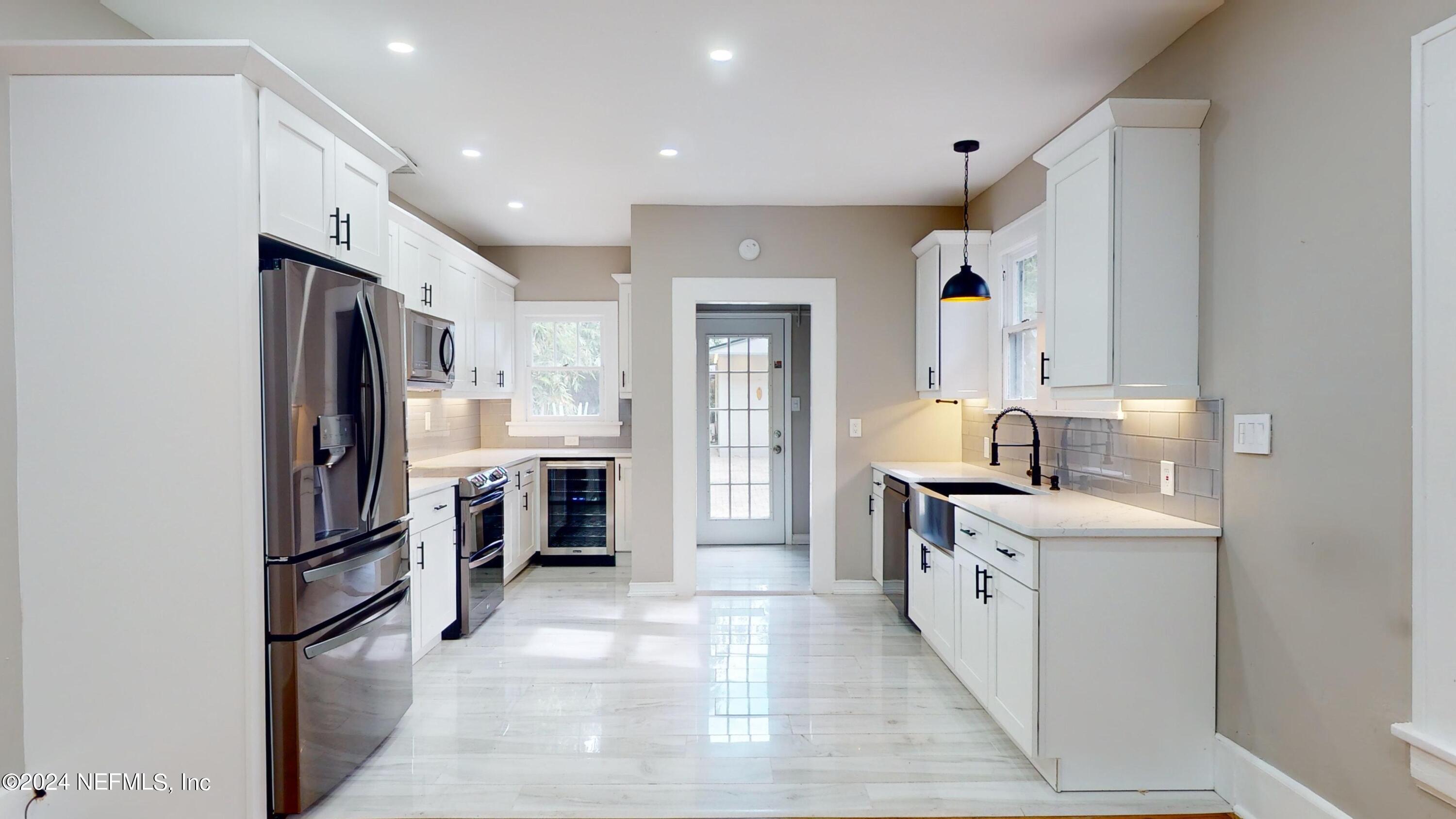 a kitchen with stainless steel appliances granite countertop a refrigerator and a sink