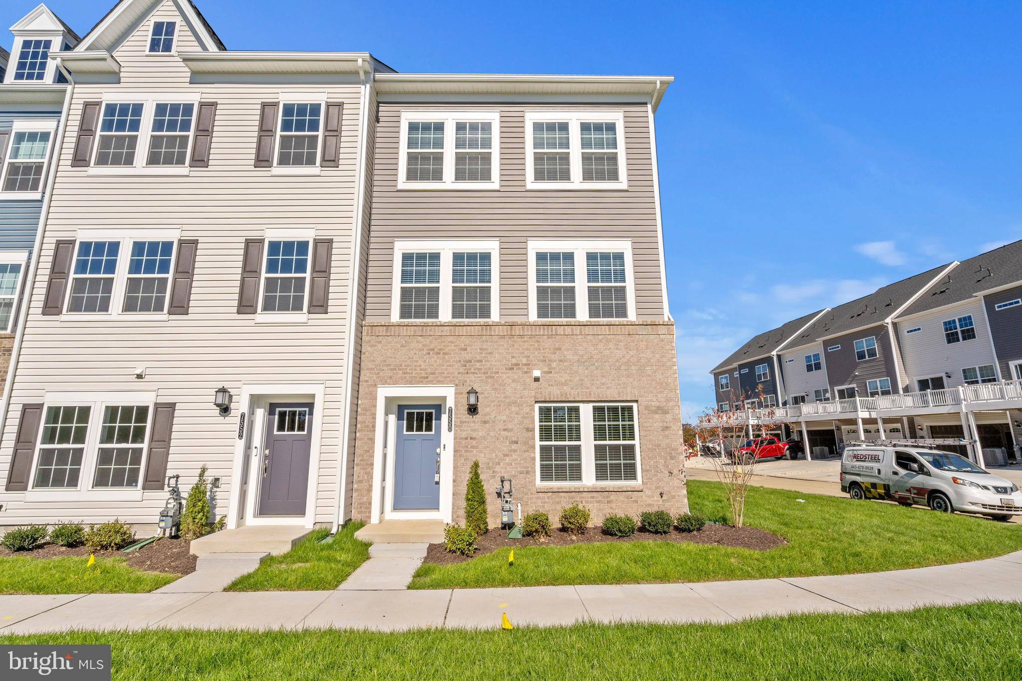 a front view of a residential apartment building with a yard and seating