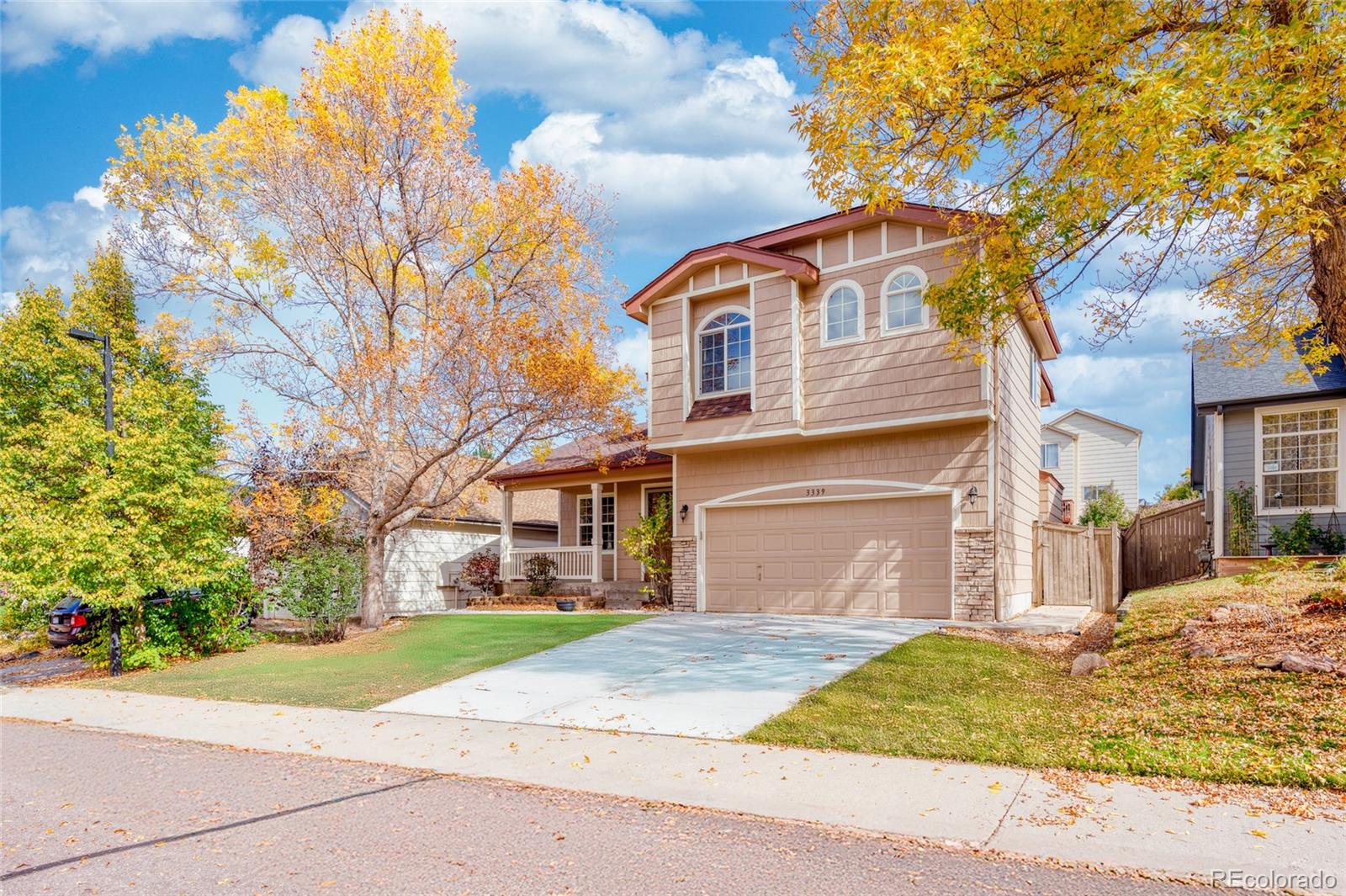 a front view of a house with a garden and trees