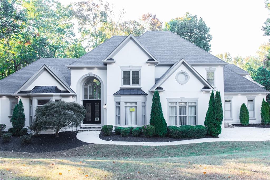 a front view of a house with yard and green space