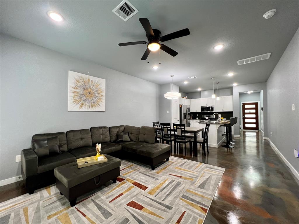 a living room with furniture and a wooden floor