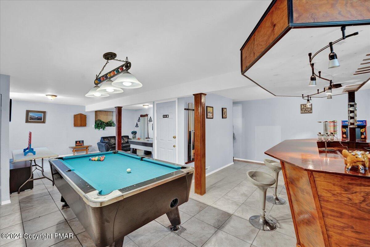 a room with pool table and windows