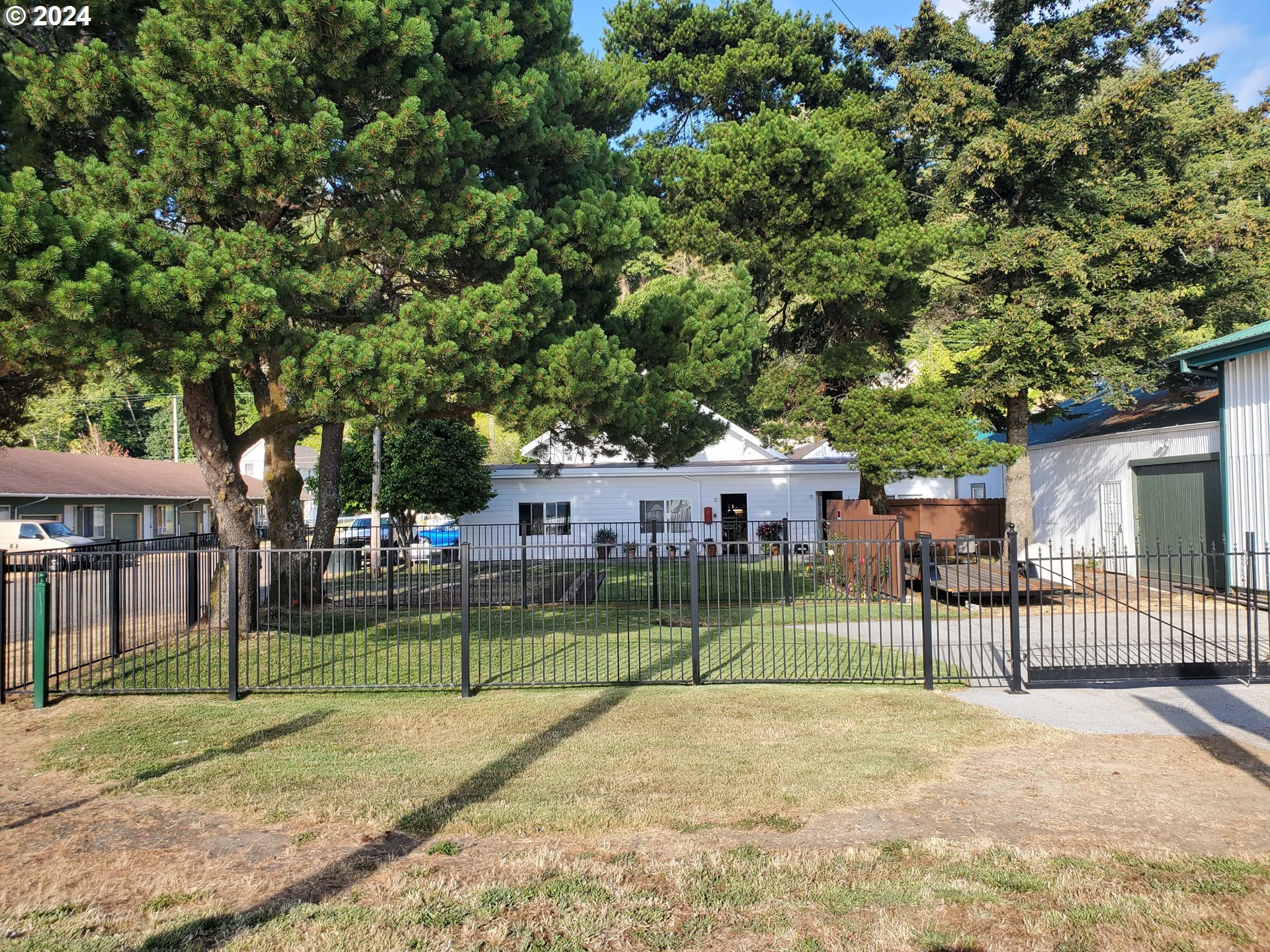 a view of a house with a big yard and large trees