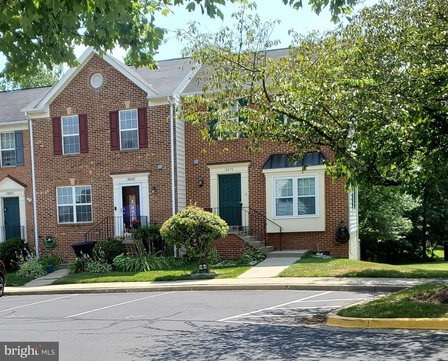 a front view of a house with a yard and trees