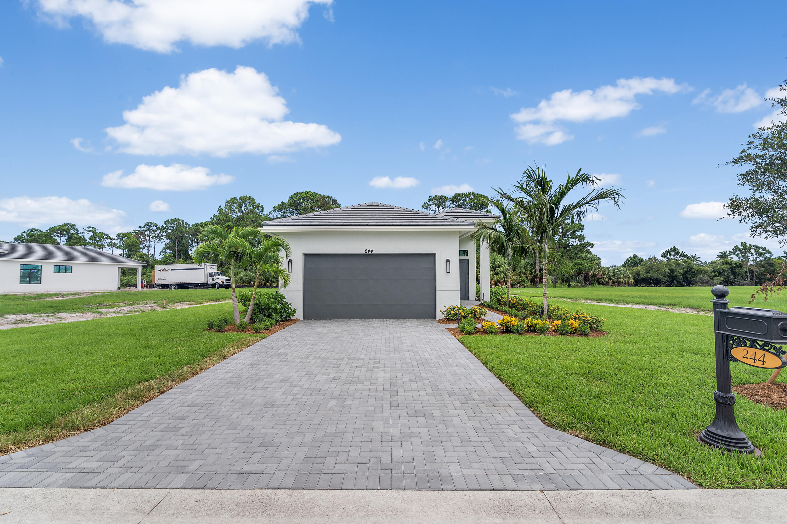 a front view of a house with garden and a yard