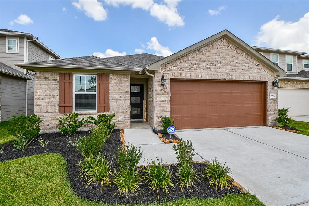 This is a single-story home featuringa brick facade, two-car garage, and aneatly landscaped front yard.