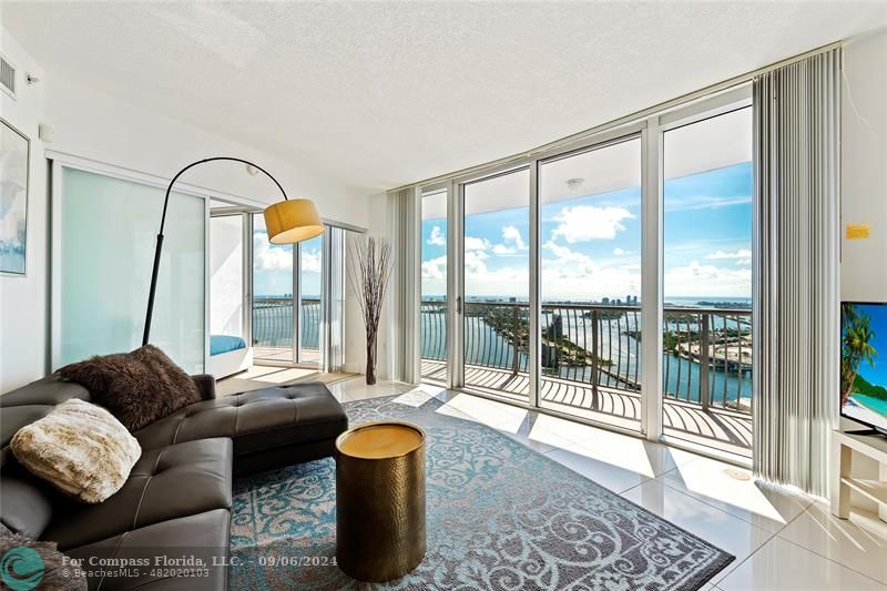 a living room with furniture and a floor to ceiling window