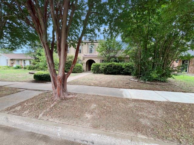 a front view of a house with a yard and trees