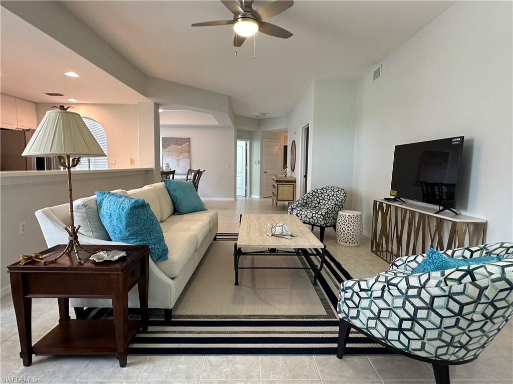 Living room with ceiling fan and light tile patterned floors