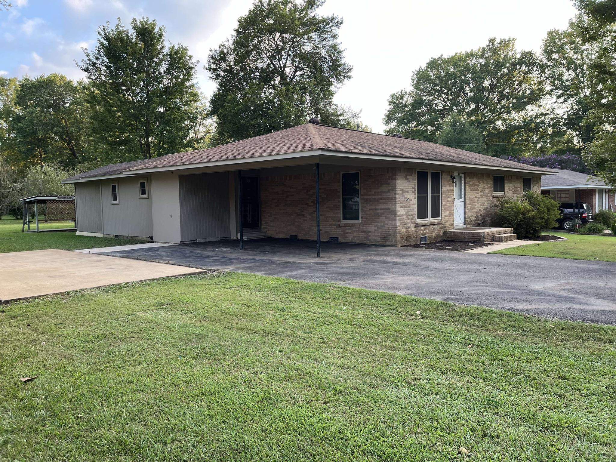 Single story home featuring a front yard and a carport