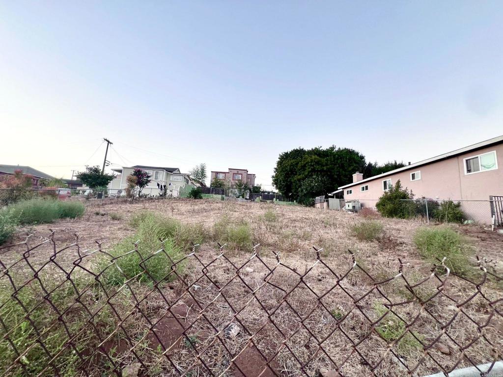 a view of a dry yard with wooden fence