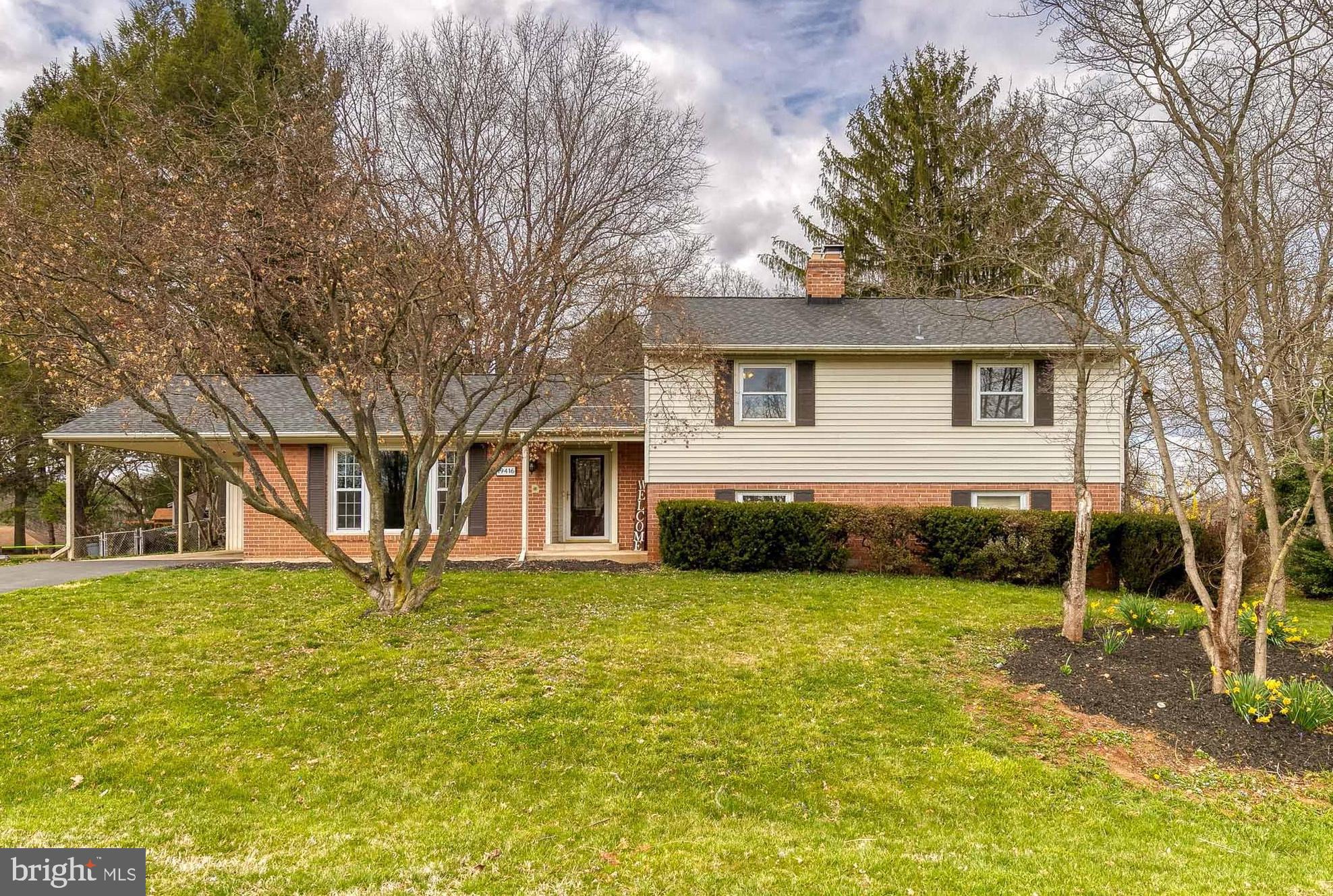 a front view of house with yard and green space