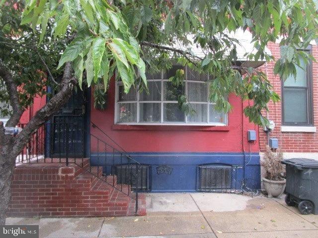 a front view of a house with a tree