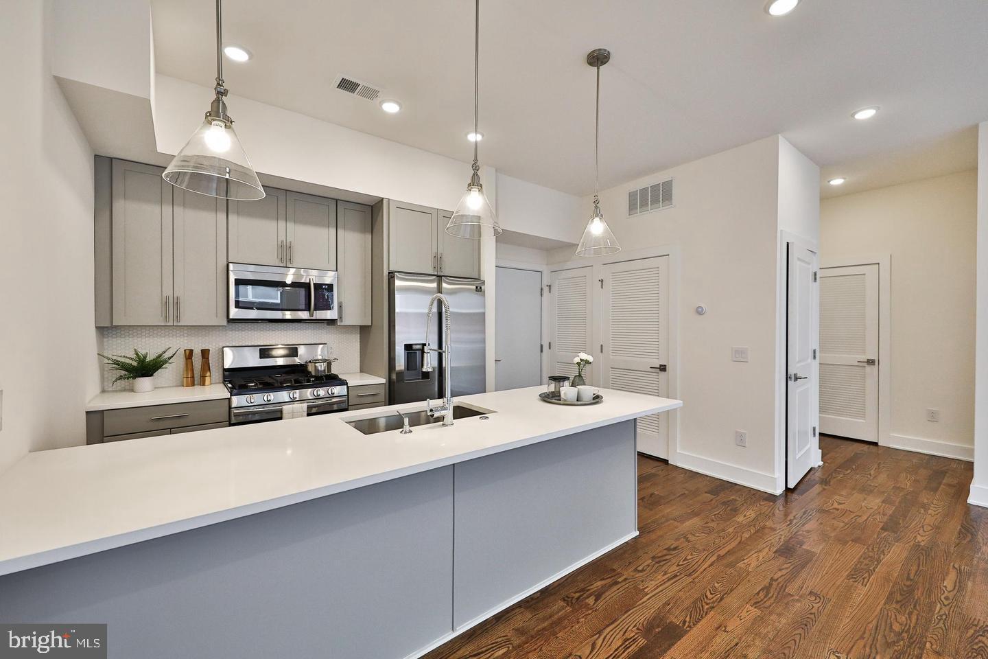 a open kitchen with stainless steel appliances a stove sink refrigerator and cabinets