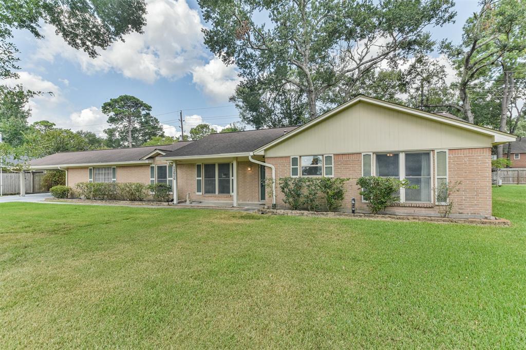 This is a single-story brick home with a well-maintained lawn, featuring a covered entrance and an attached garage, set in a neighborhood with mature trees.