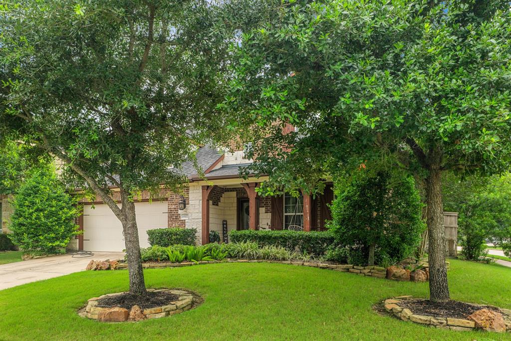 a front view of a house with a yard and a tree