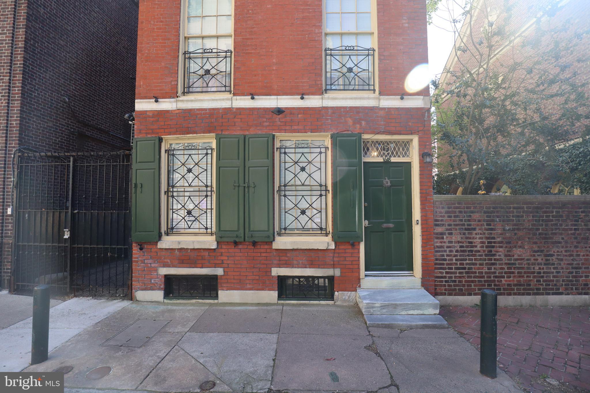 a view of a brick building with a bench and a potted plant