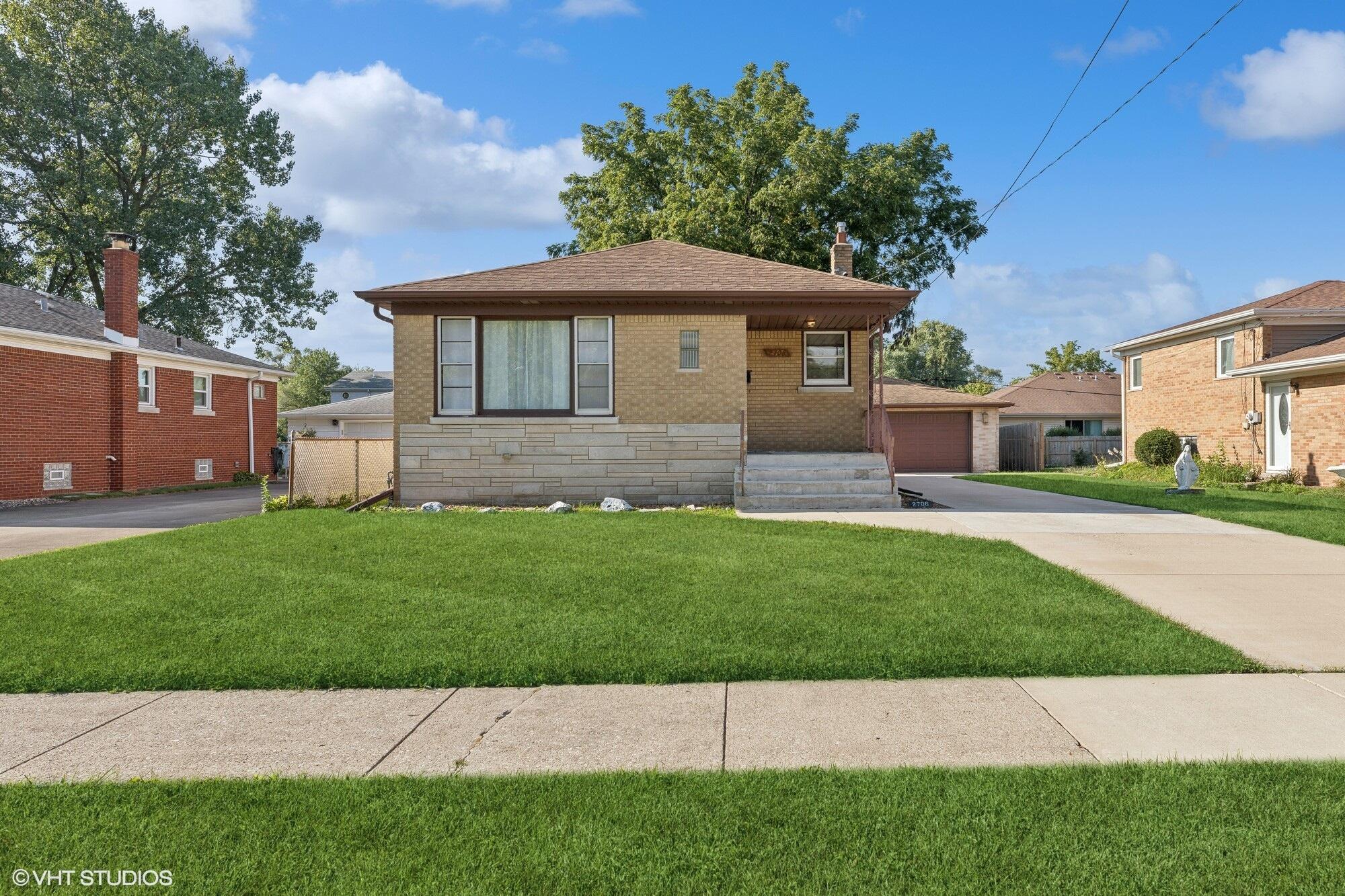 a front view of a house with a garden and yard