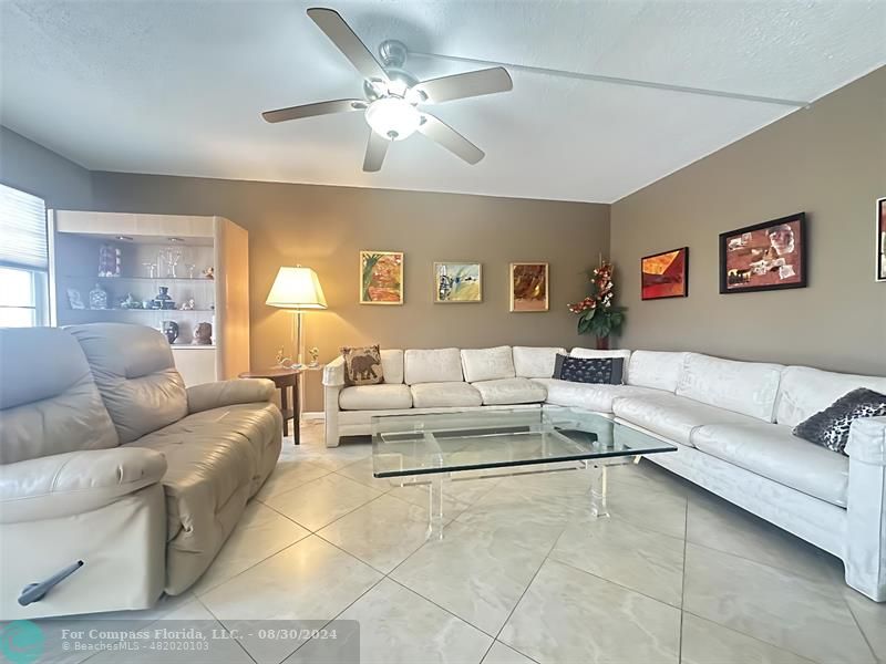 a living room with furniture and a ceiling fan