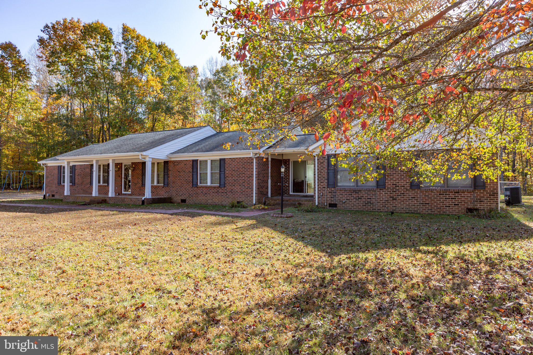 a front view of a house with a yard and trees