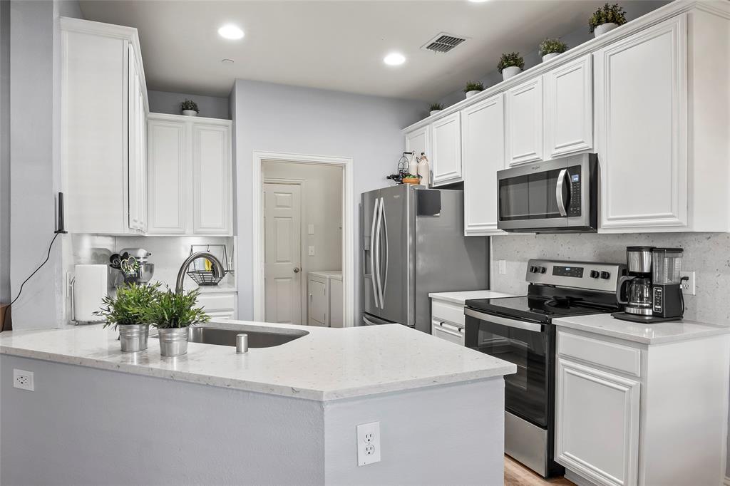 a kitchen with stainless steel appliances a microwave sink refrigerator and cabinets