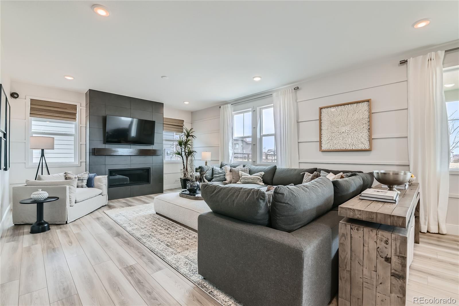 a living room with furniture a fireplace and a flat screen tv