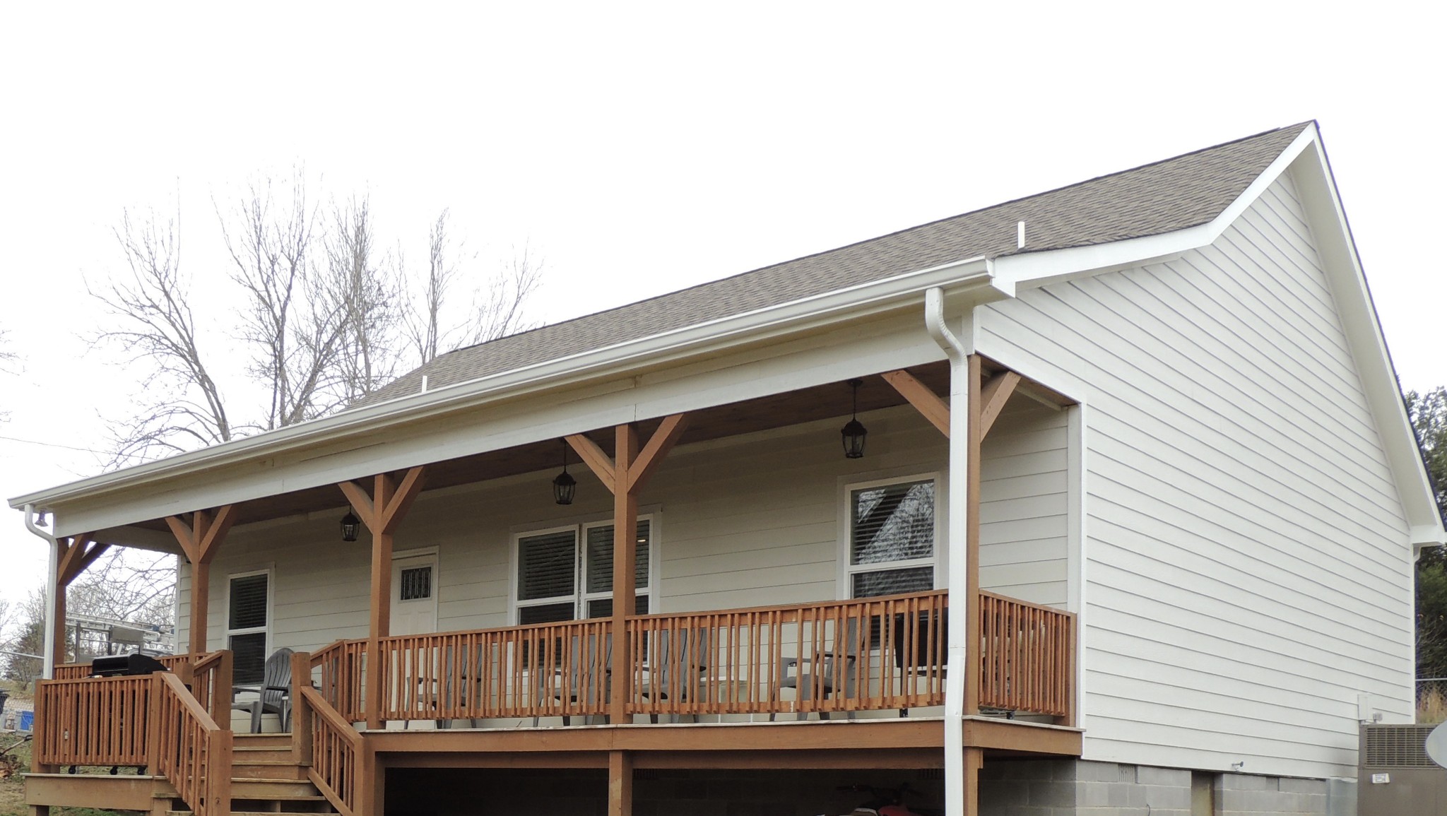 a view of house with roof deck and wooden fence