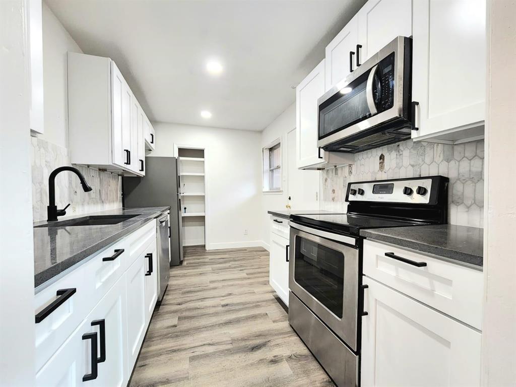 a kitchen with stainless steel appliances granite countertop a stove and a sink