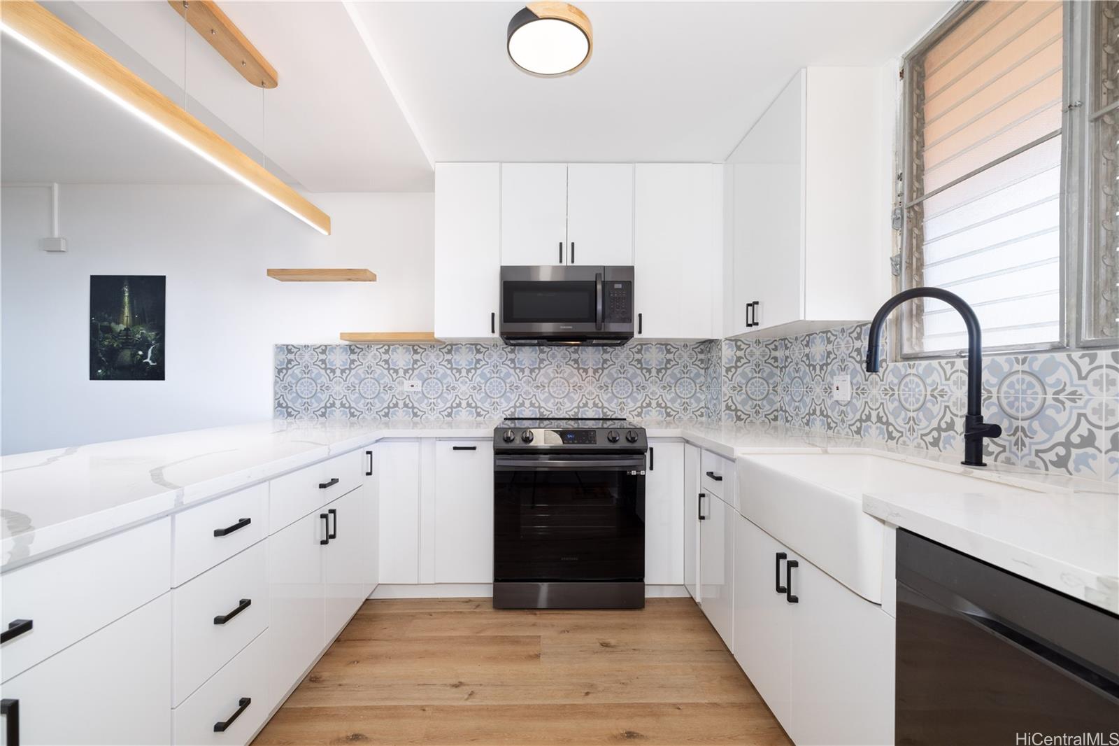 a kitchen with granite countertop a stove sink and cabinets