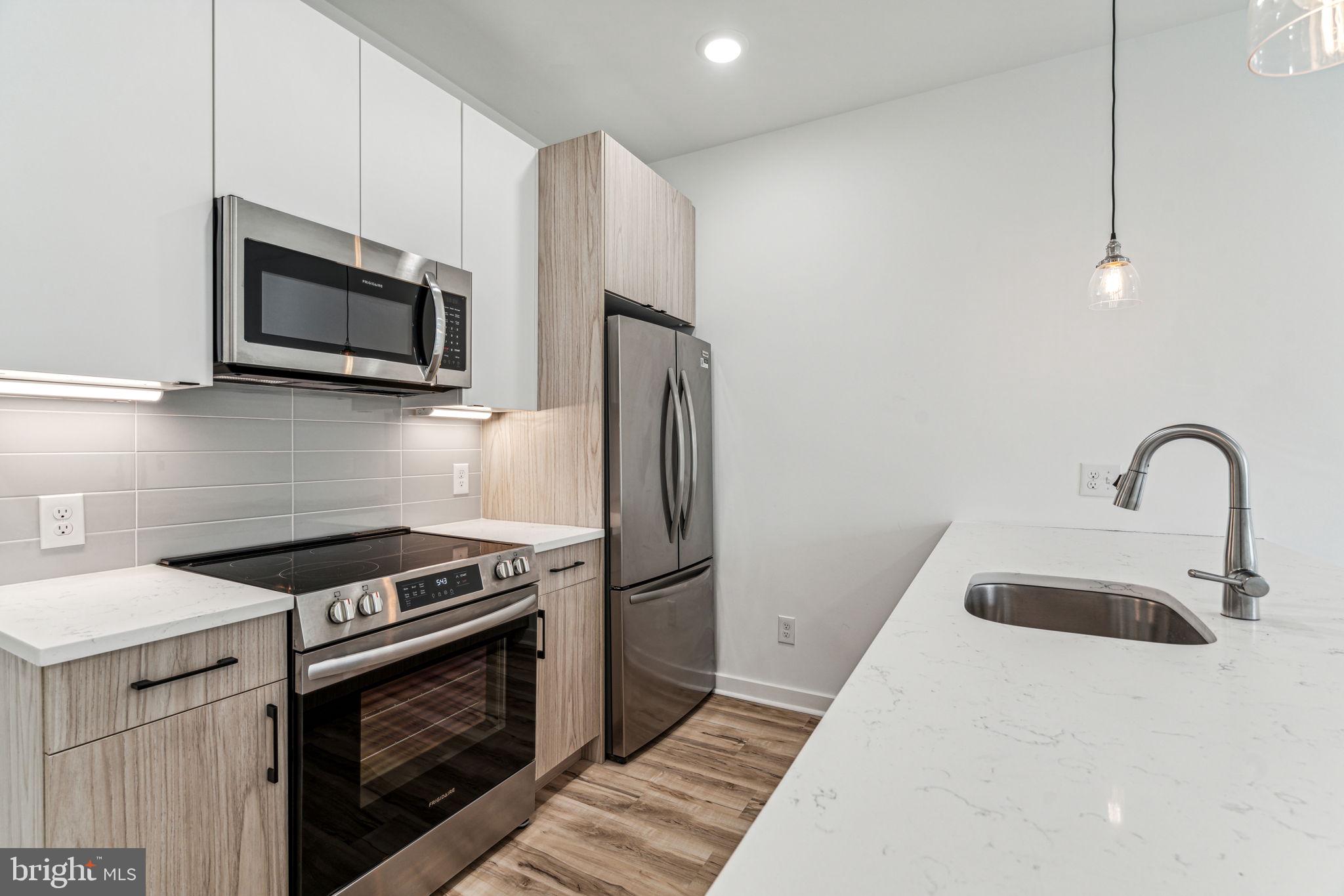 a kitchen with stainless steel appliances a stove microwave and a sink