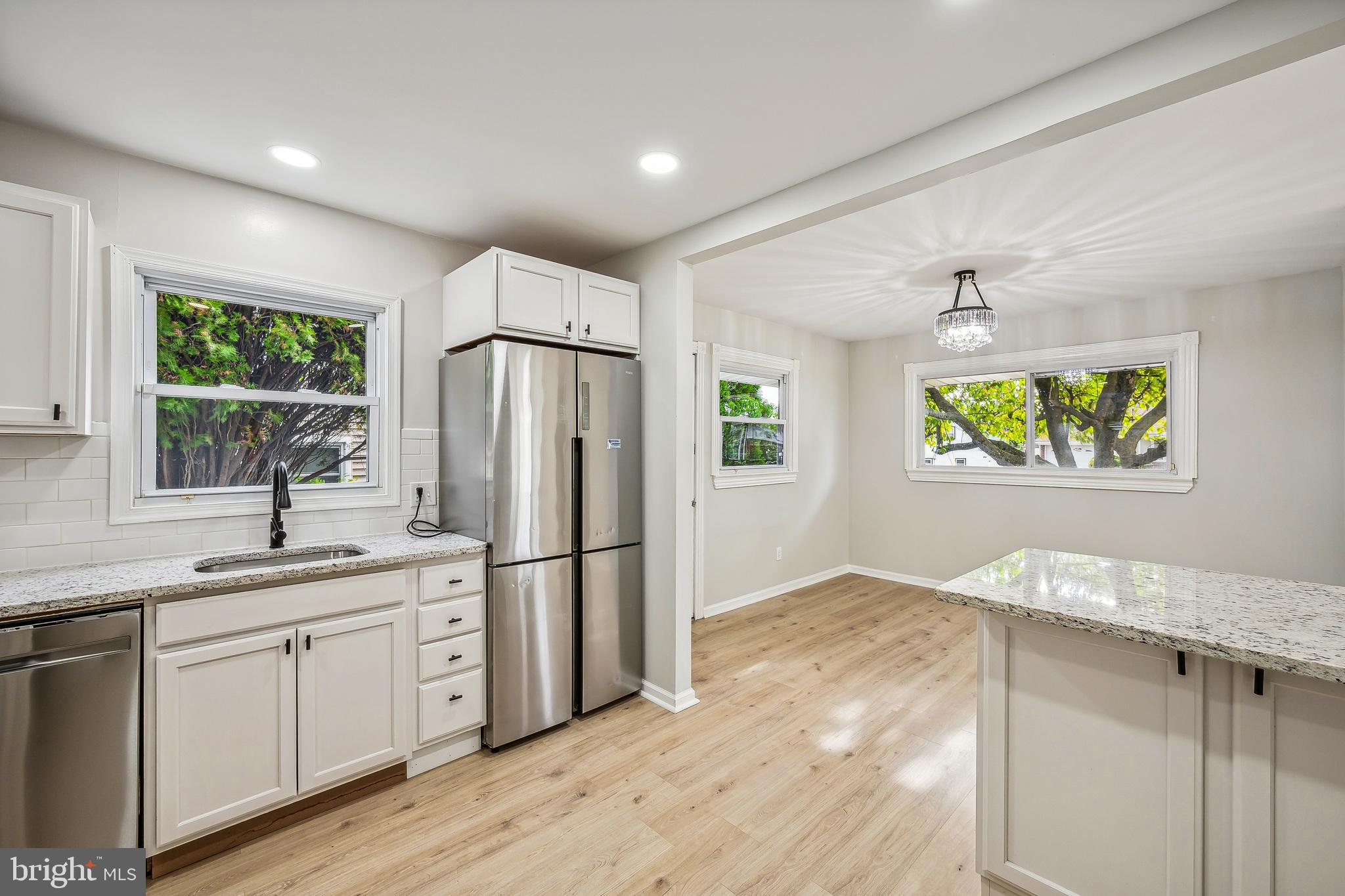 a kitchen with stainless steel appliances granite countertop a refrigerator and a sink