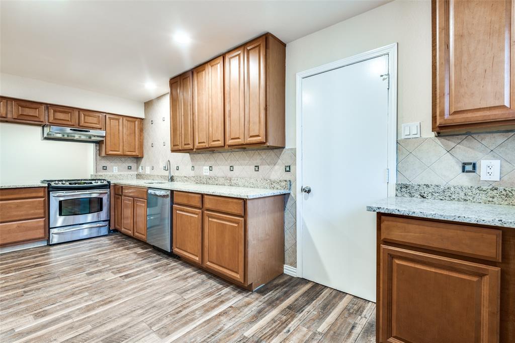 a kitchen with a refrigerator stove top oven and sink