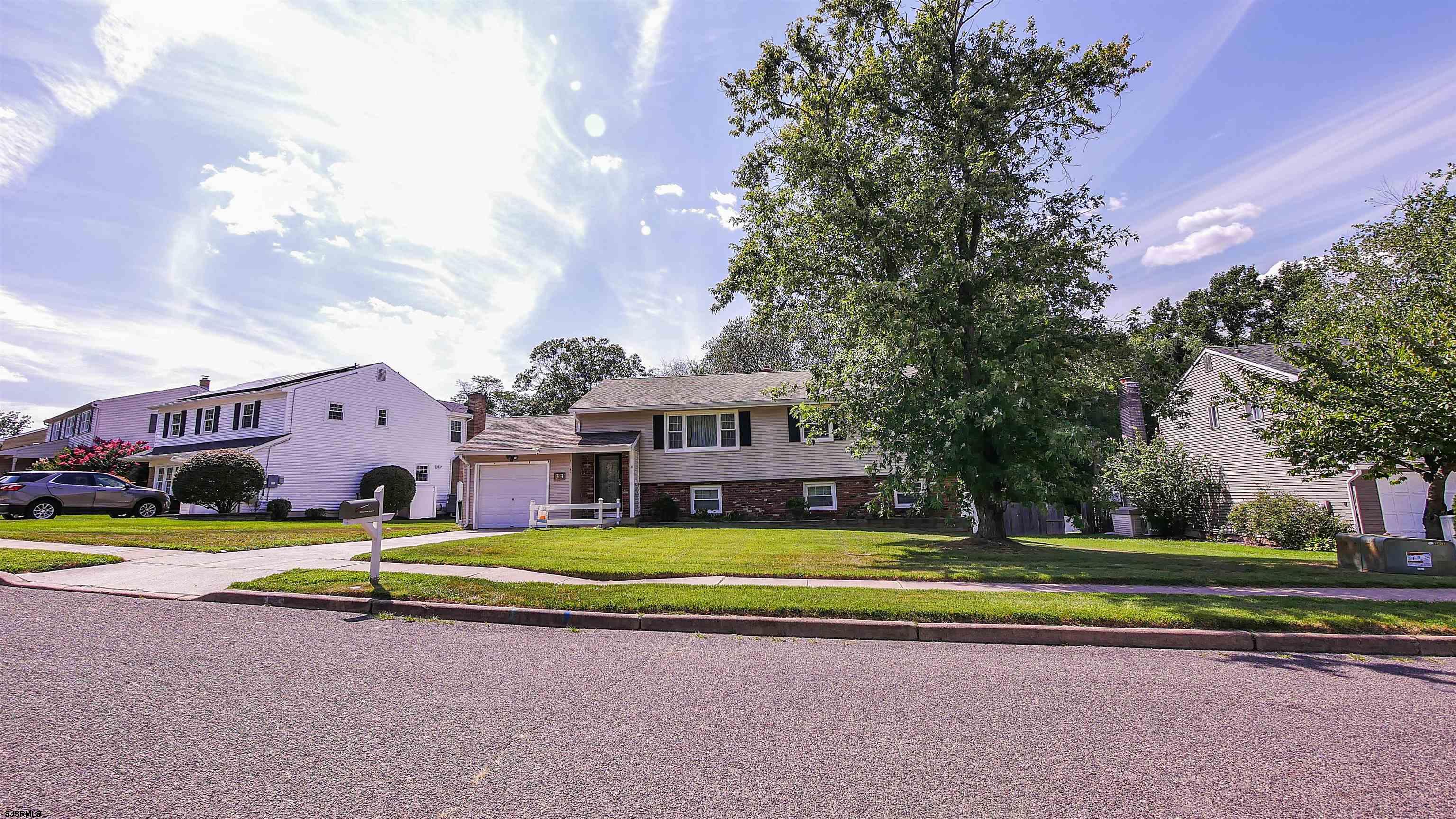 a view of a house with a big yard and palm trees