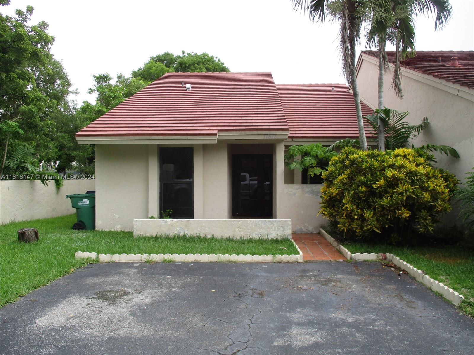 a front view of a house with a garden and plants