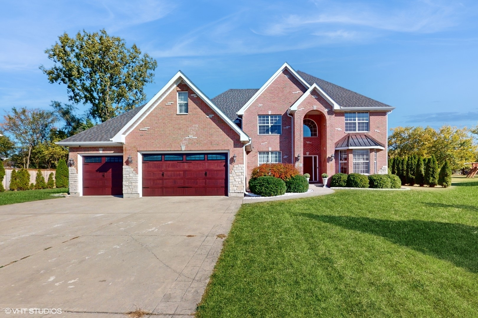 a front view of a house with yard and green space