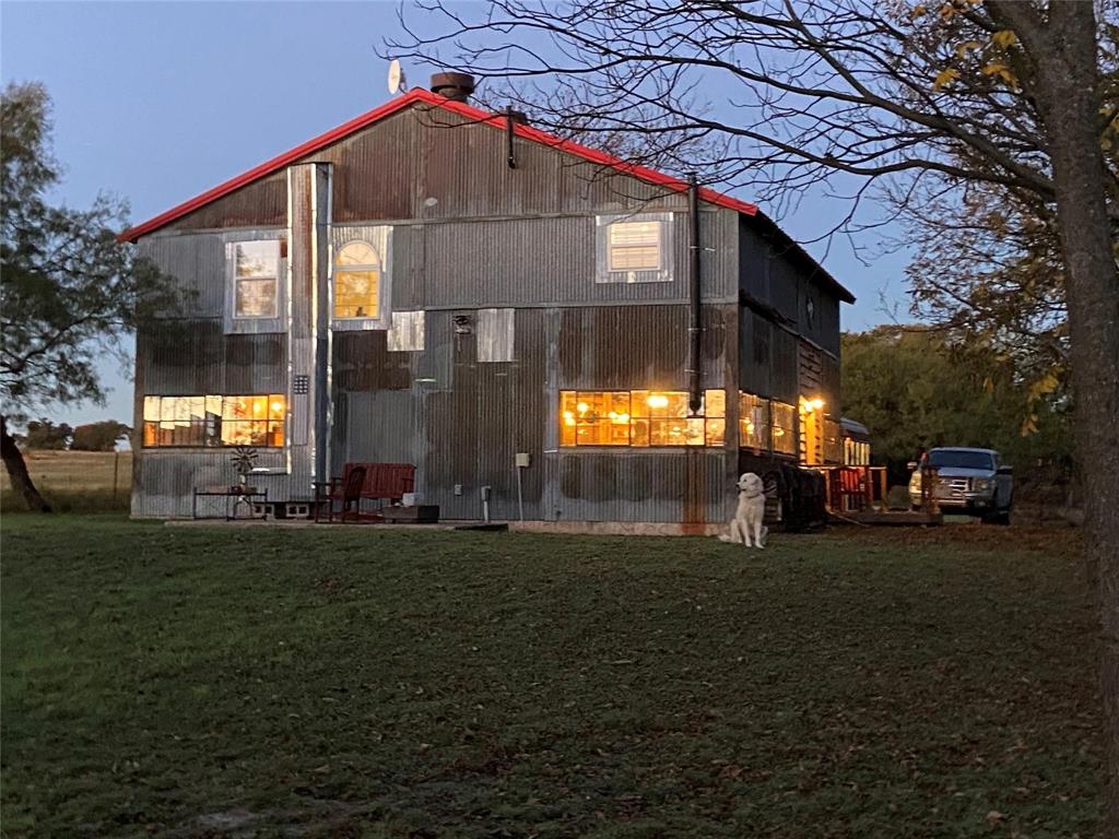 Back house at dusk with a yard