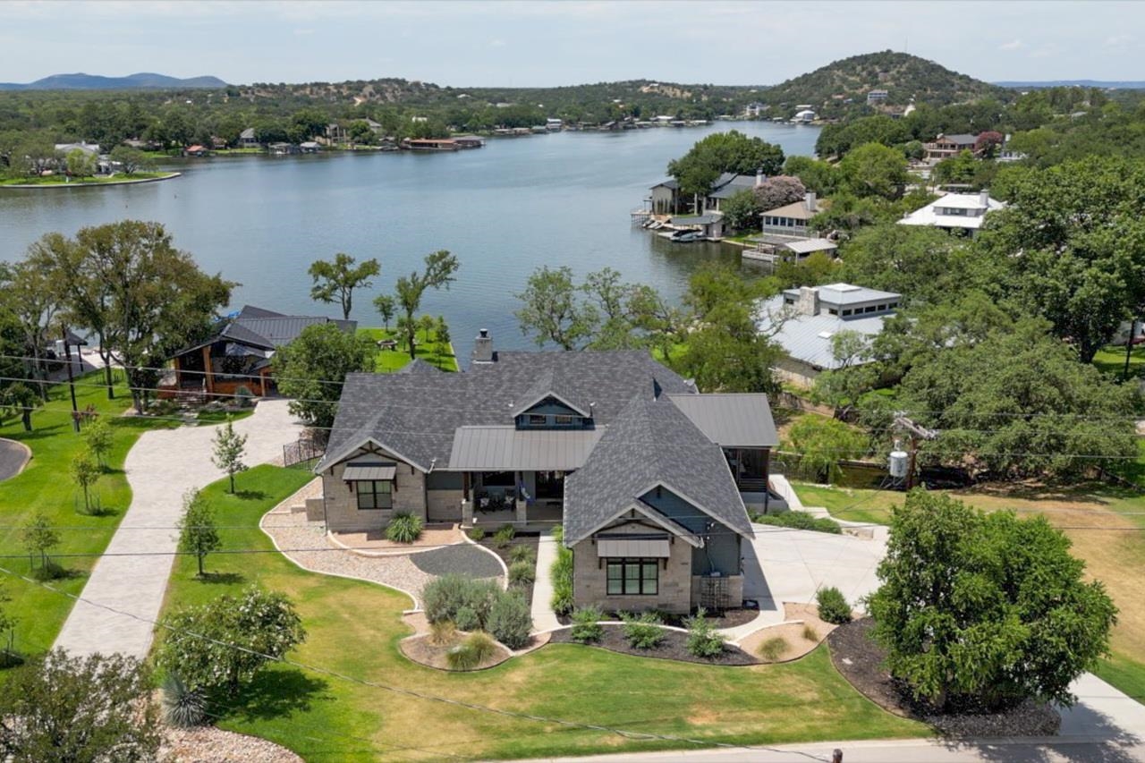 an aerial view of a house with outdoor space and lake view