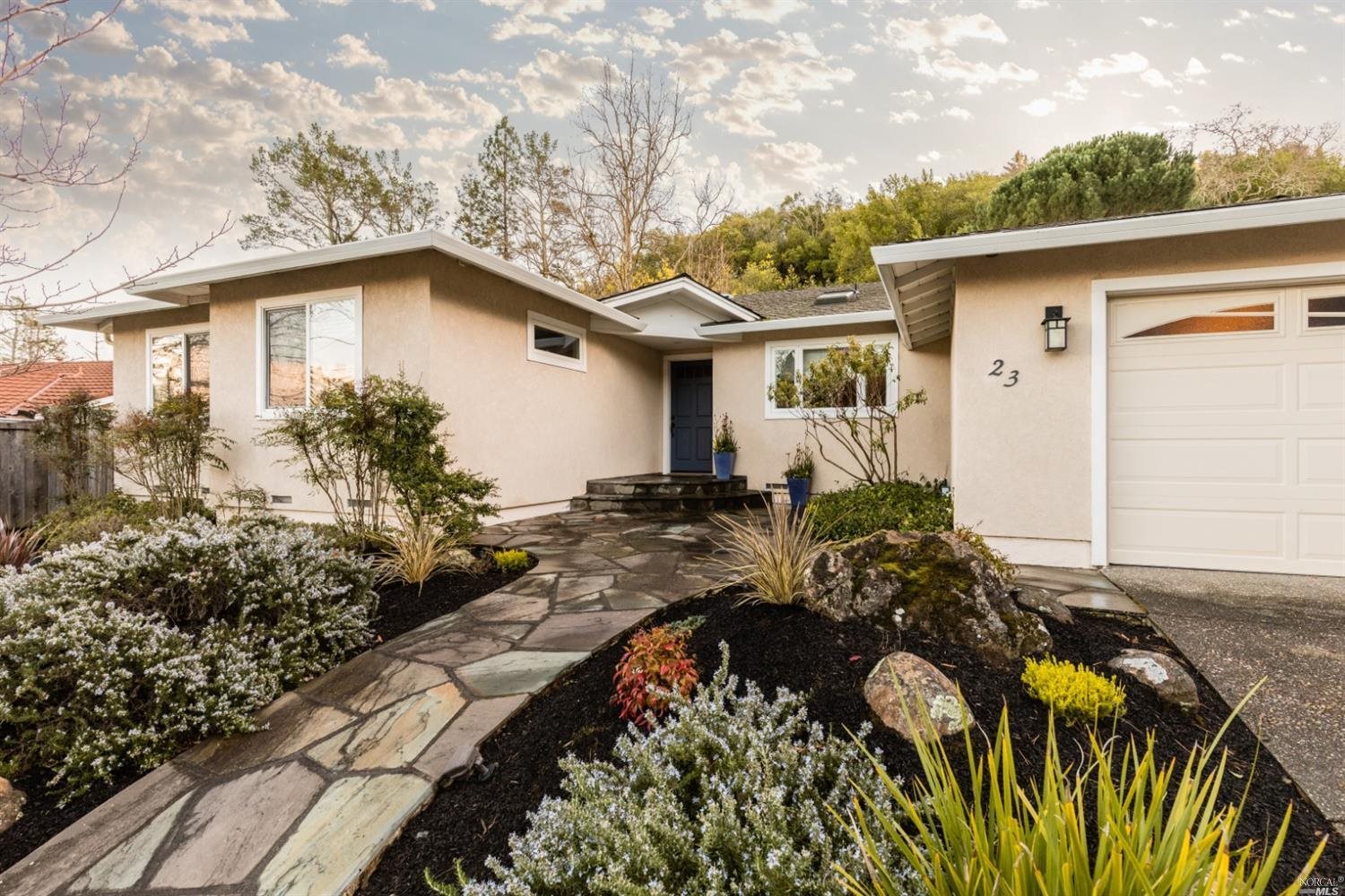 a front view of house with yard and trees around