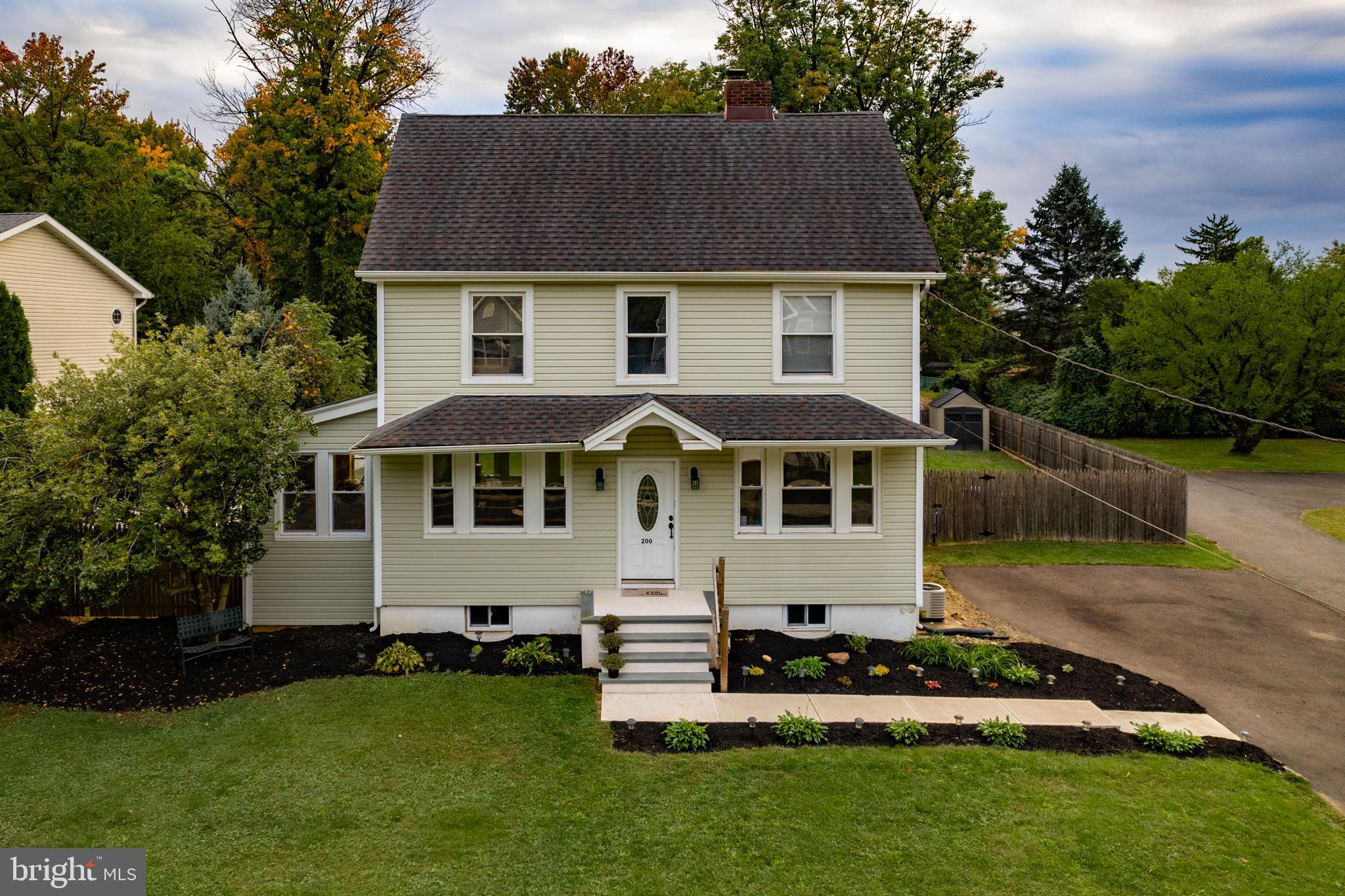 a front view of a house with a garden and yard