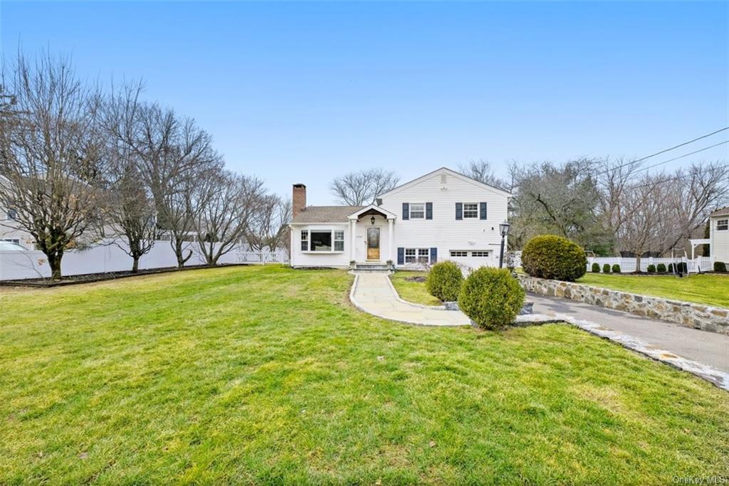 a view of a house with a big yard and large trees