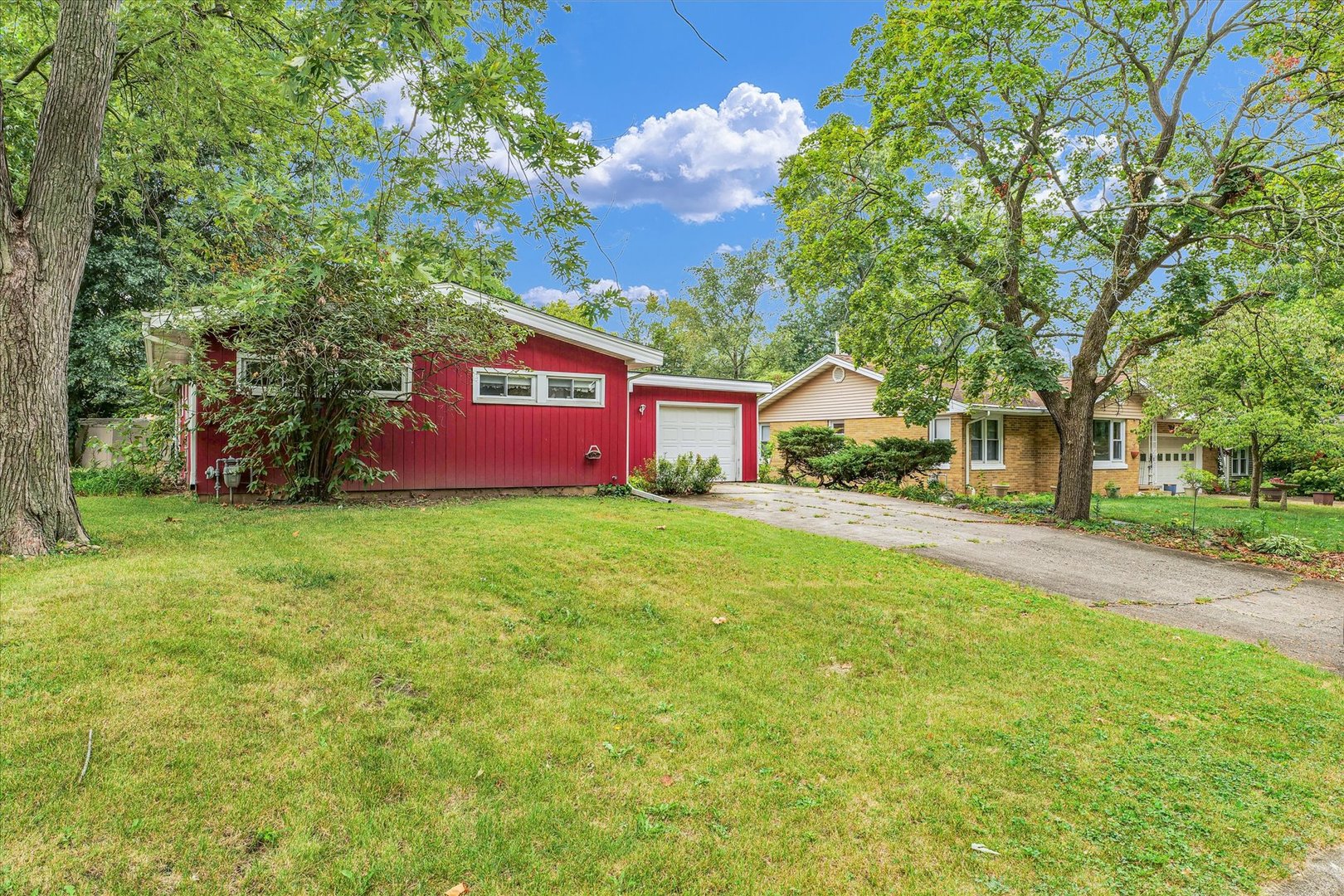 a front view of a house with a yard and trees