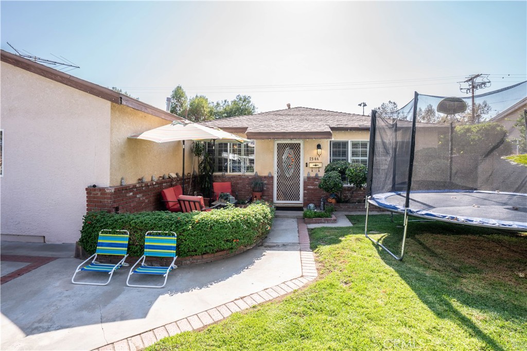 a view of a house with backyard swimming pool and sitting area