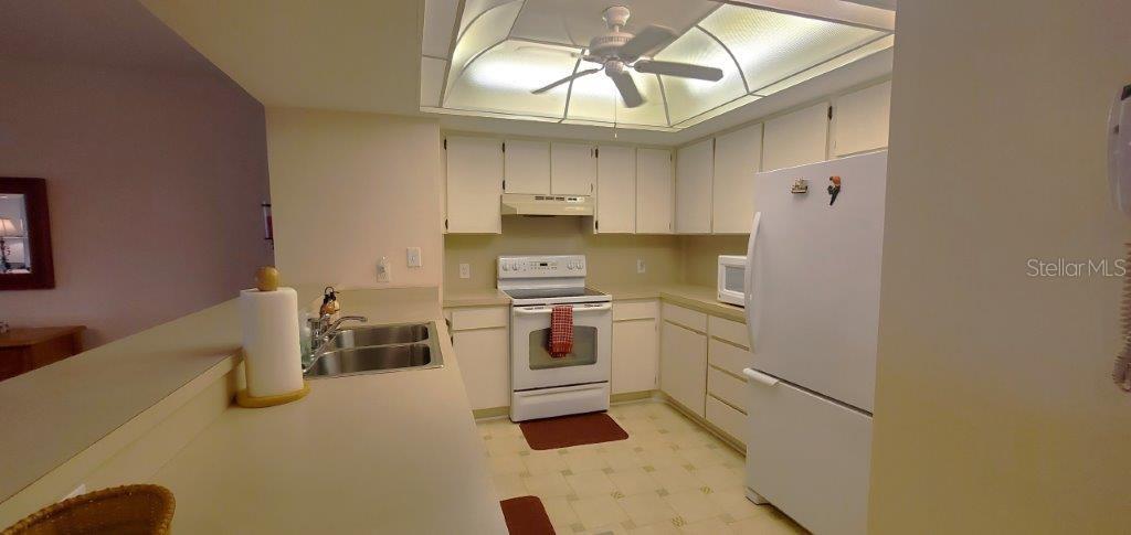 a kitchen with a refrigerator and white cabinets