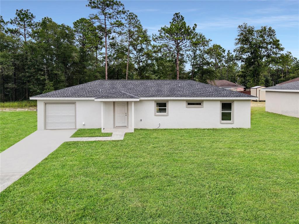 a aerial view of a house next to a big yard and large trees