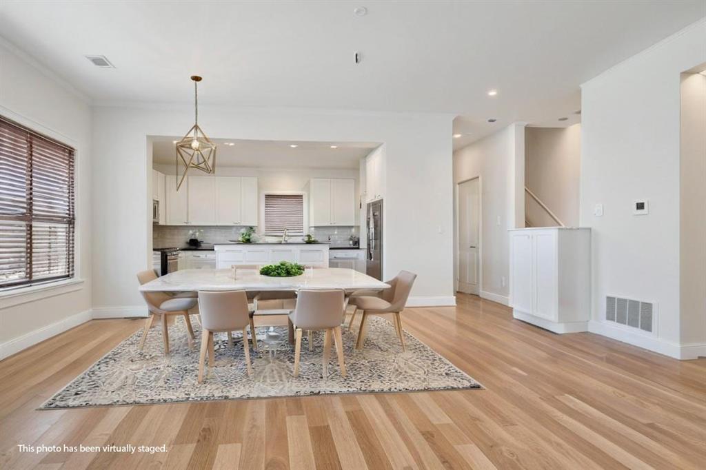 a dining room with wooden floor a chandelier a wooden table and chairs