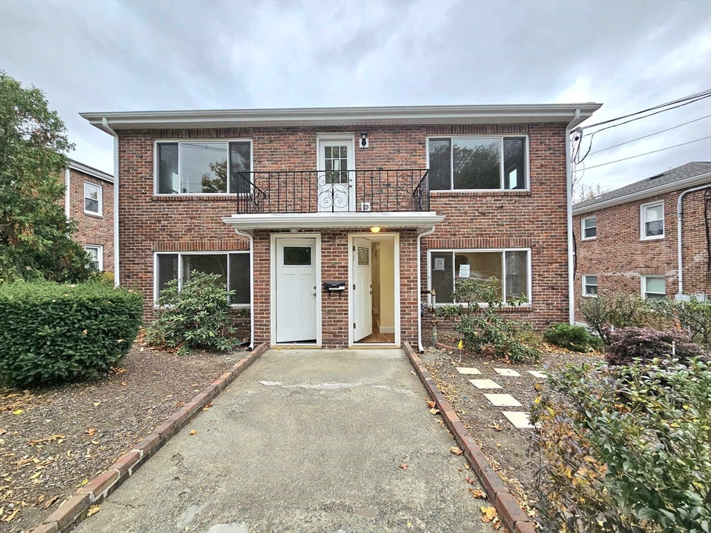 front view of a brick house with a yard